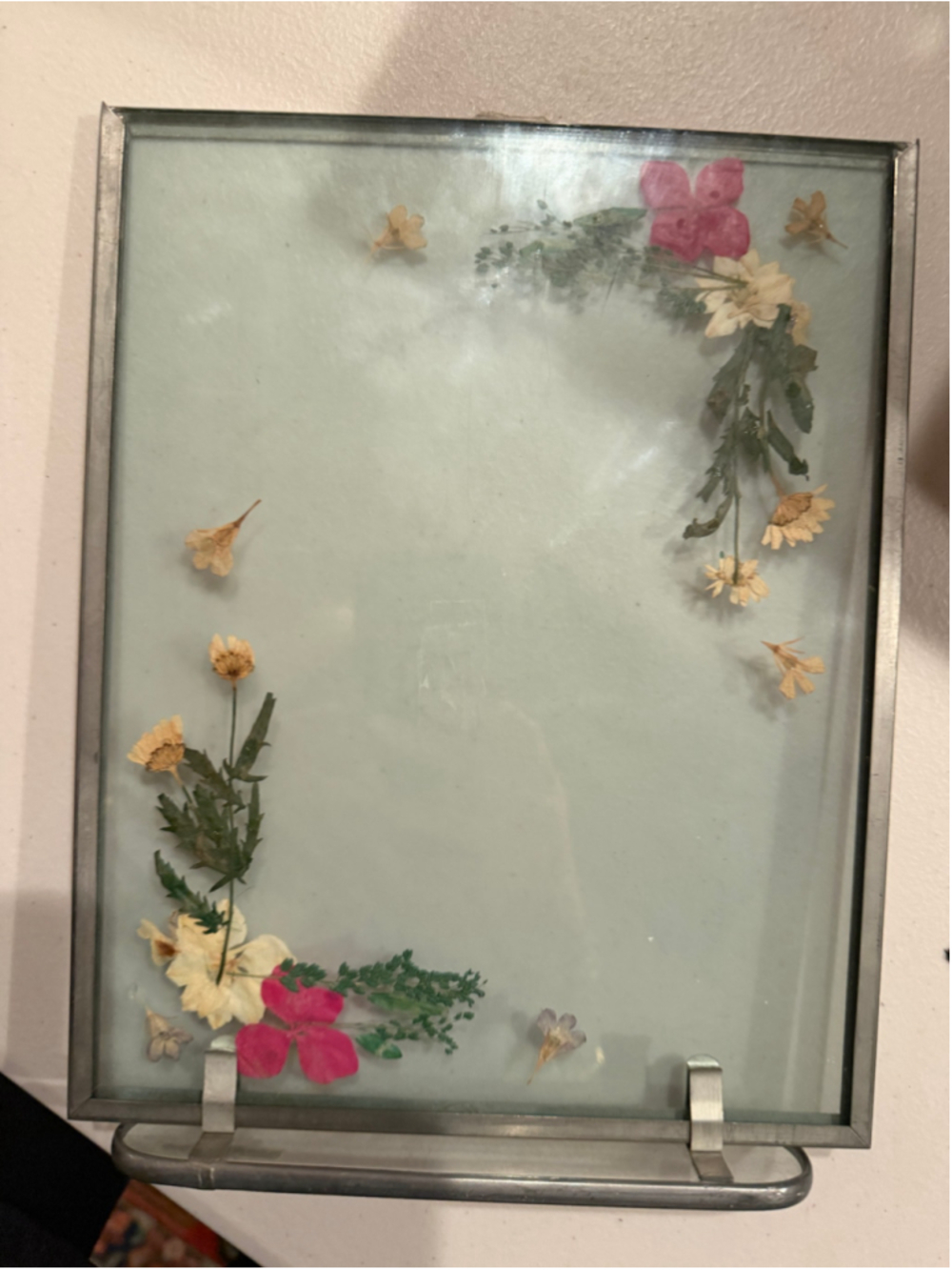 Pressed flower glass frame with dried flowers and greenery arranged in a decorat